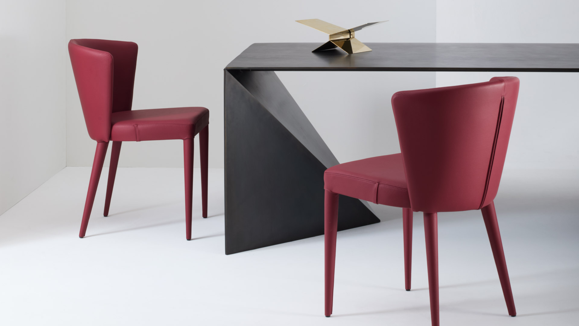 Sedia imbottita di design Atena rivestita in pelle in ambiente contemporaneo con tavolo di design Julia Italia